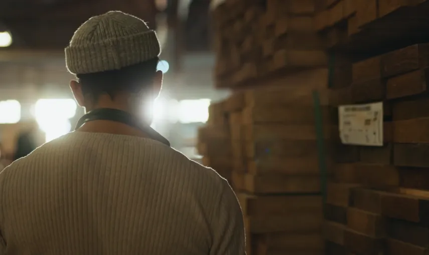 Craftsman among stacks of seasoned timber
